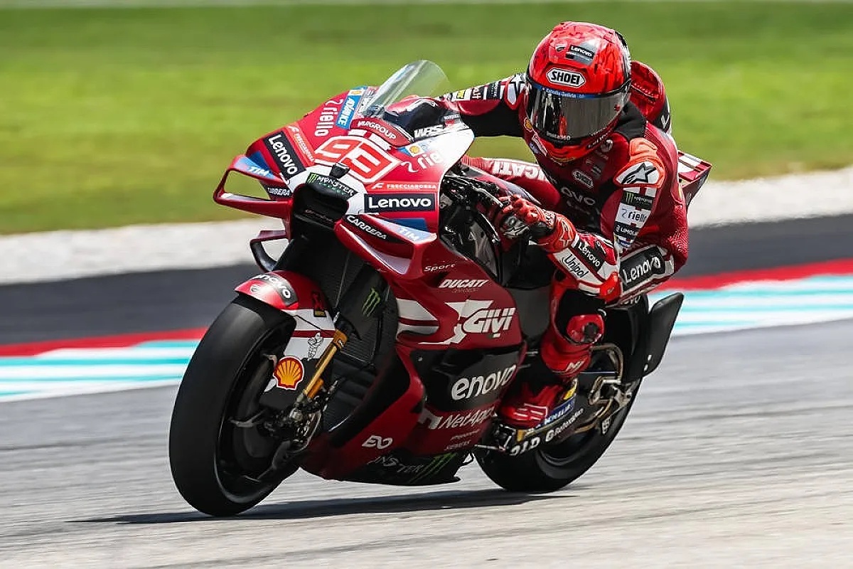 Marc Márquez on a red Ducati Desmosedici with Lenovo and Ducati livery, leaning into a corner at the Sepang MotoGP circuit.