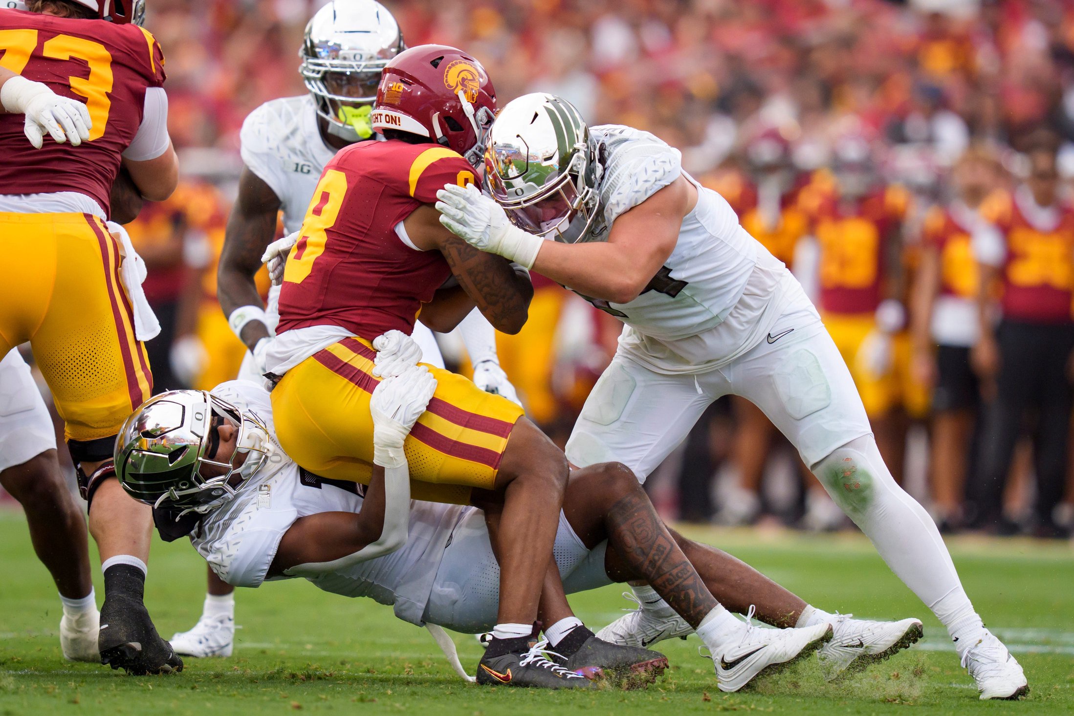 Oregon inside linebacker Dylan Williams, left, and Oregon outside linebacker Teitum Tuioti bring down USC running back King Miller as the Oregon Ducks face the USC Trojans on Sept. 26, 2026, at Los Angeles Memorial Coliseum in Los Angeles, California.