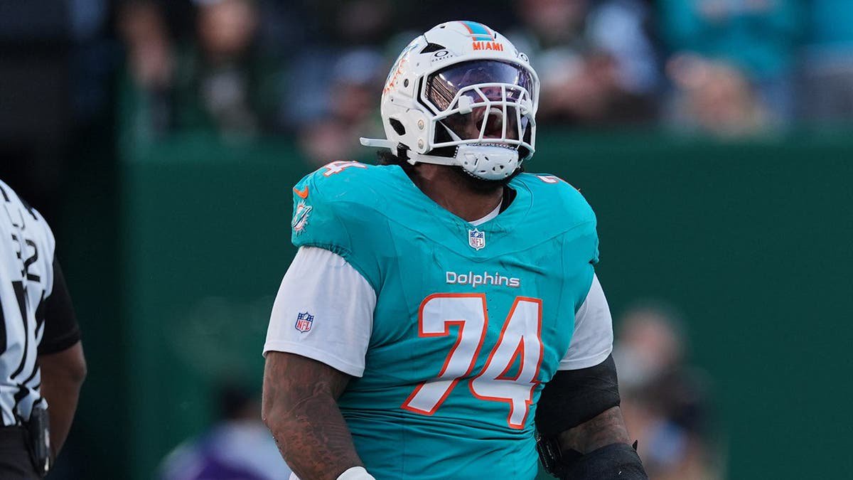 Kadyn Proctor, Miami Dolphins offensive tackle, celebrates a first down during an NFL game.