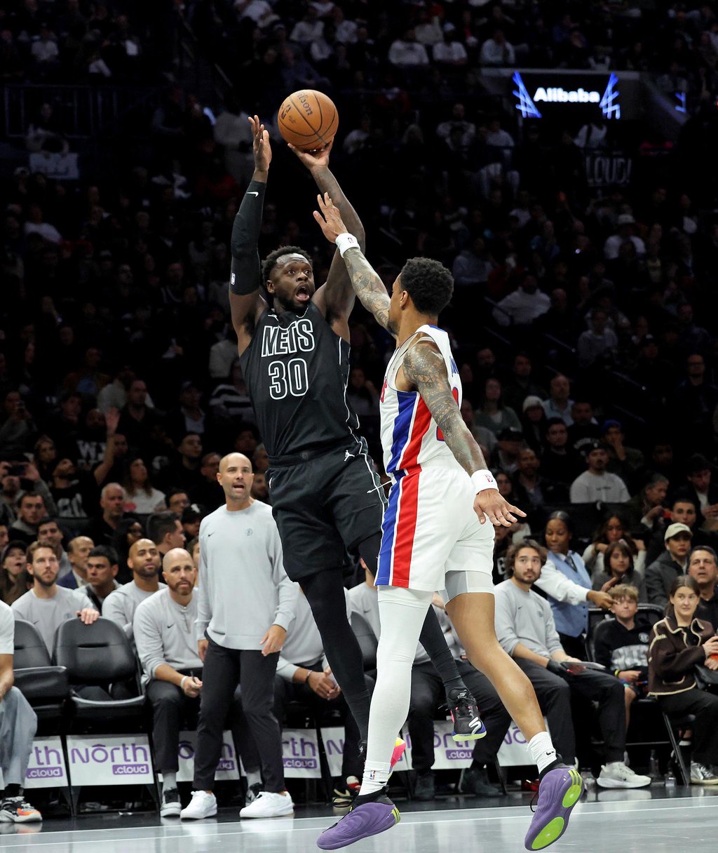 Brooklyn Nets forward Julius Randle shoots a basketball over a Detroit Pistons defender during a game at Barclays Center.