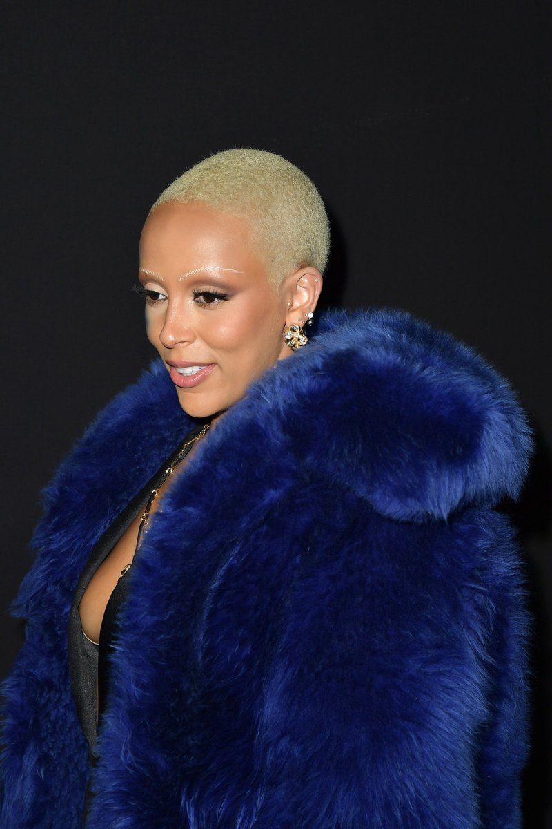 Doja Cat posing on a red carpet in a blonde buzzcut hairstyle