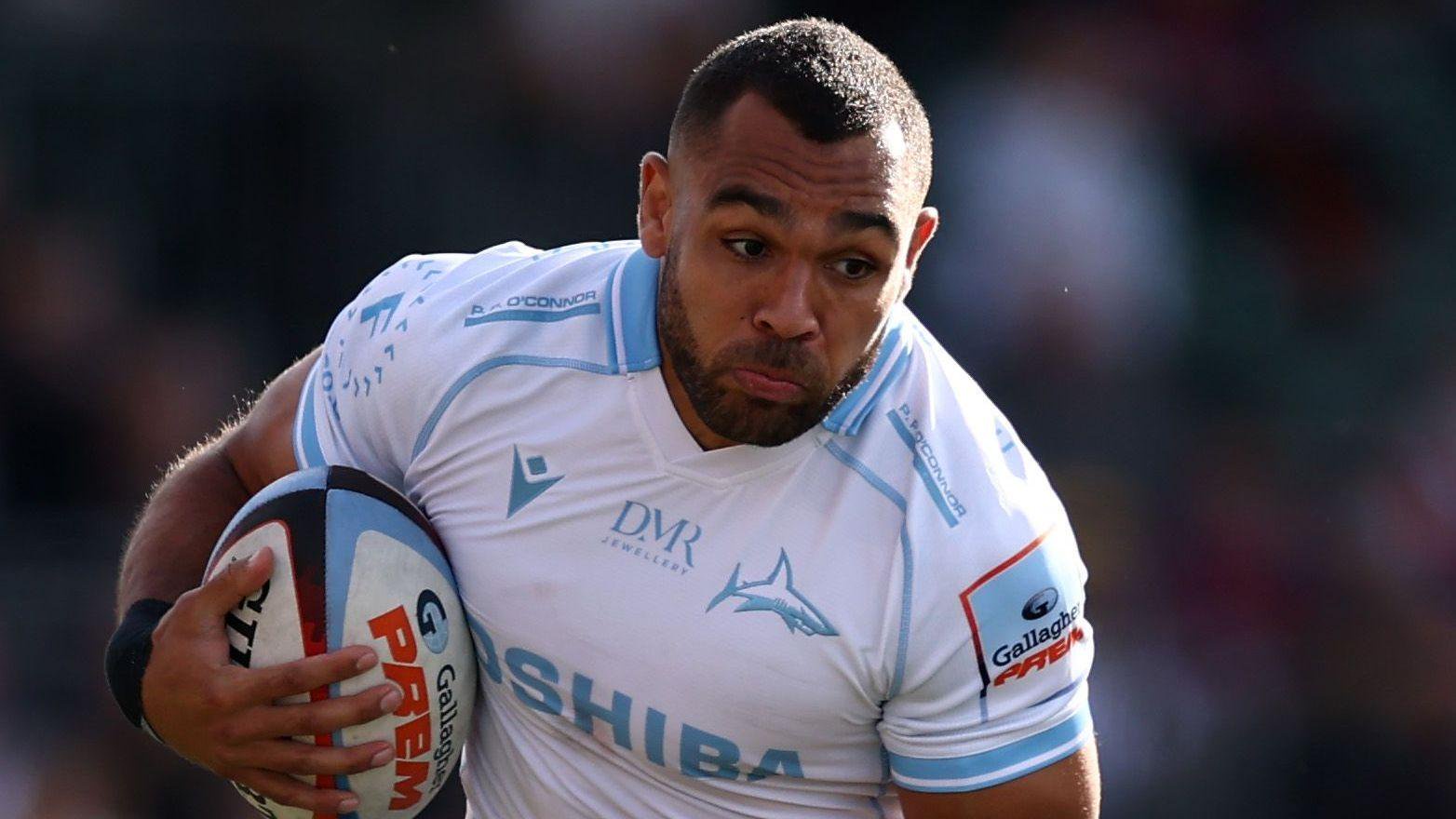 Joe Marchant in action for Sale Sharks with the ball shielded by his right arm