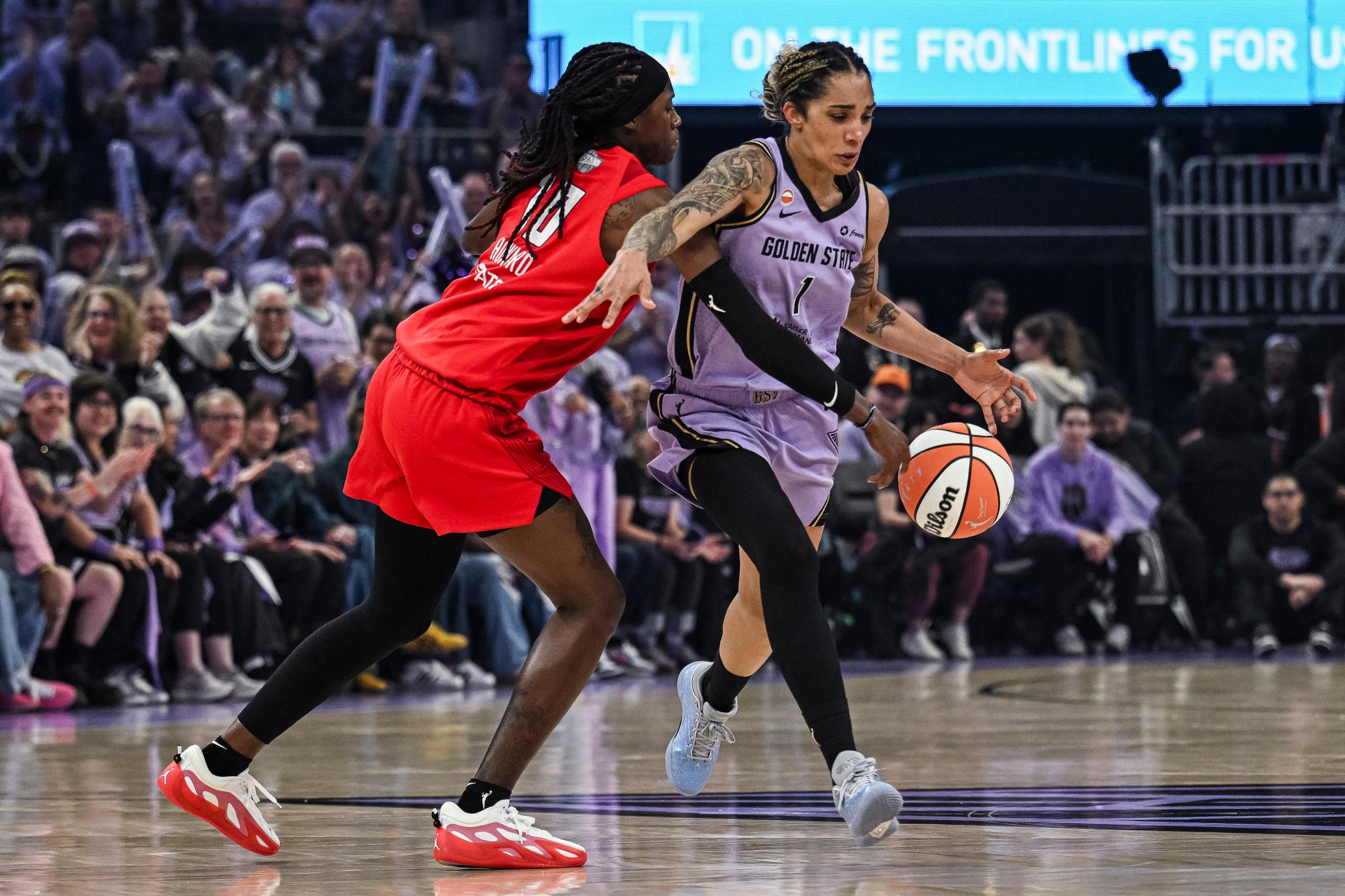 Gabby Williams drives past Rhyne Howard during a WNBA game.