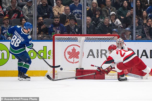 Vancouver Canucks' Jonathan Lekkerimaki (88) scores on Carolina Hurricanes goaltender Pyotr Kochetkov (52) as Sebastian Aho (20) defends during the first period of an NHL hockey game in Vancouver on Tuesday, Oct. 20, 2026. (Ethan Cairns/The Canadian Press via AP)