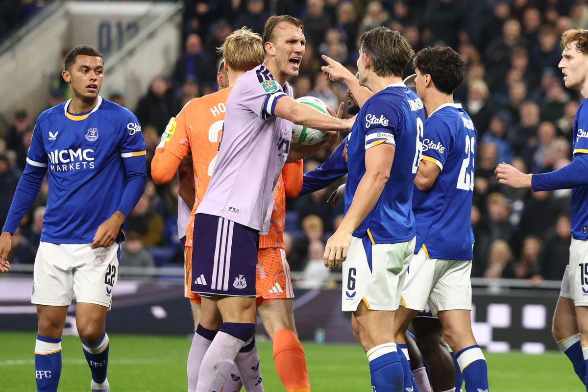 Newcastle United's Dan Burn clashes with Everton's James Tarkowski