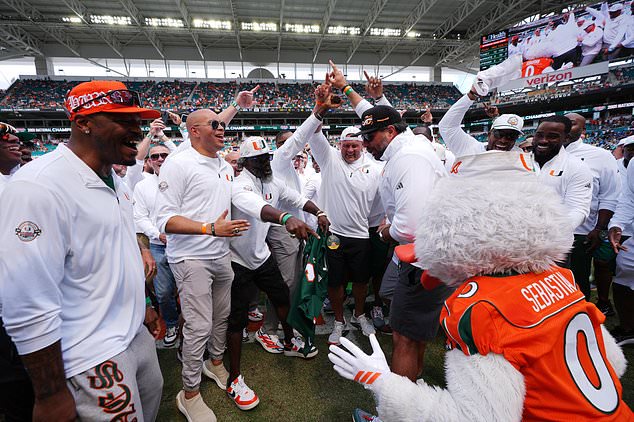 Members of Miami's 2001 National Championship football team celebrate with Miami mascot Sebastian the Ibis as they are honored at halftime of an NCAA college football game between Miami and Pittsburgh, Saturday, Oct. 24, 2026, in Miami Gardens, Fla. (AP Photo/Rebecca Blackwell)