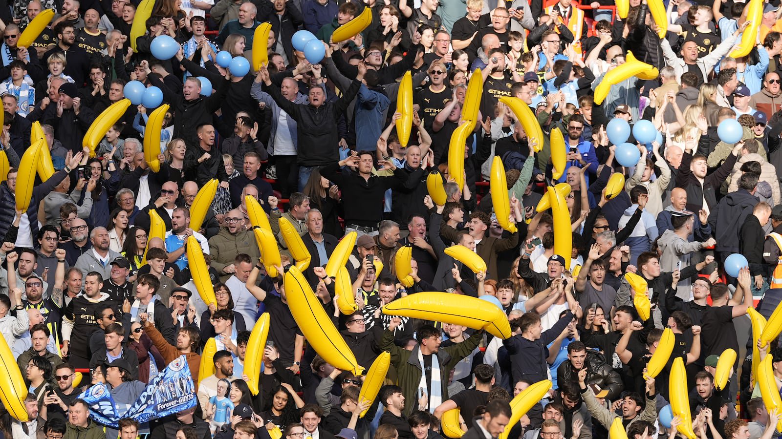Manchester City fans hold up inflatable bananas at Anfield .
