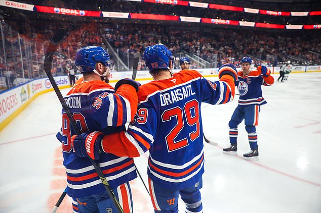 Edmonton Oilers' Vasily Podkolzin (92) and Leon Draisaitl (29) celebrate Draisaitl's goal against the Minnesota Wild during the second period of an NHL hockey game in Edmonton, Tuesday, Oct. 20, 2026. (Codie McLachlan/The Canadian Press via AP)