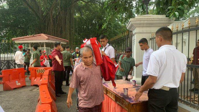Warga saat mendapatkan sembako dari Presiden Jokowi di depan Istana Bogor, Minggu (7/4/2024)