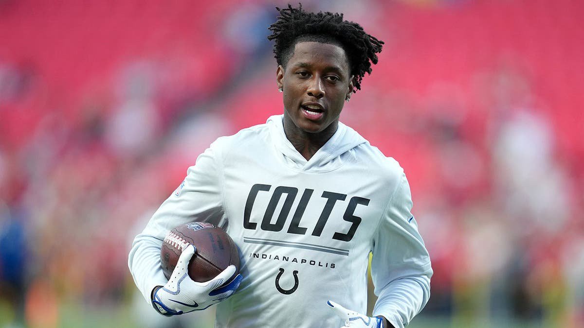 Sauce Gardner, wearing Colts uniform number 1, warms up on the field before the game.
