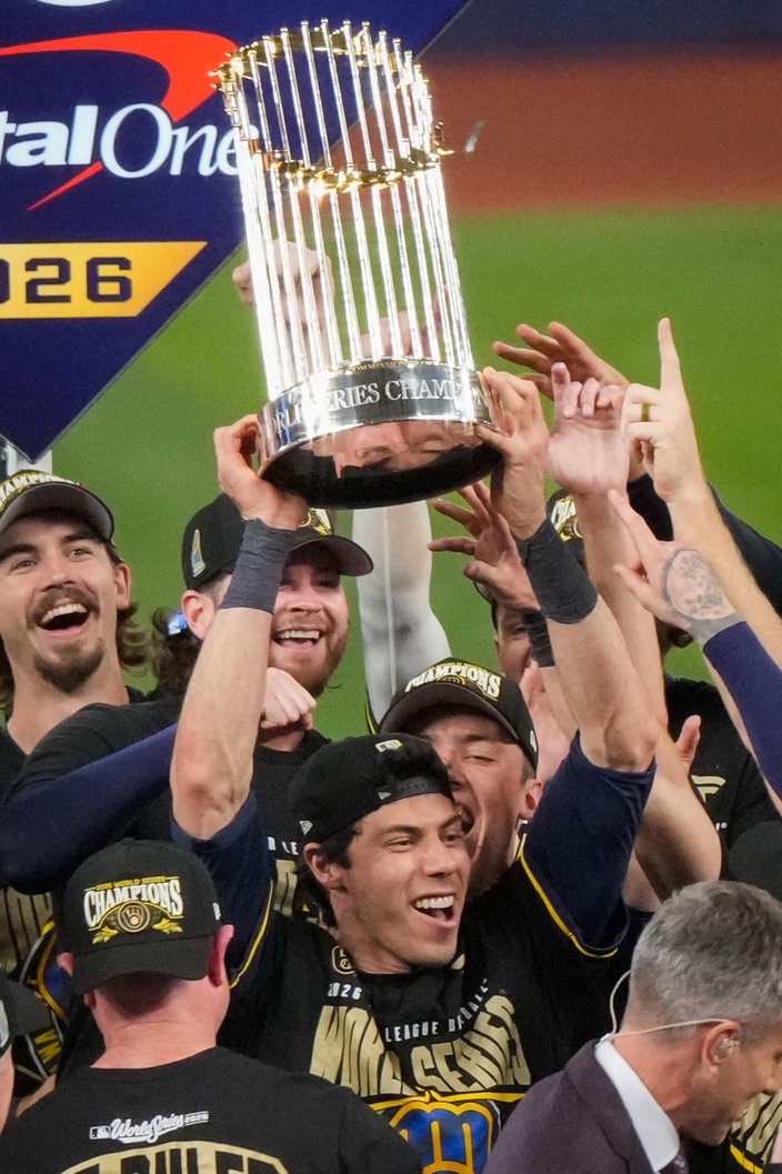 Milwaukee Brewers Christian Yelich and teammates celebrate holding the World Series trophy.