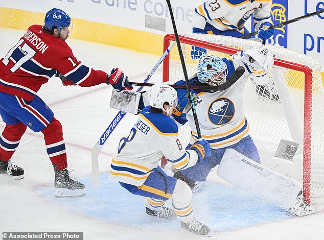 Montreal Canadiens' Josh Anderson (17) tries to tip the puck past Buffalo Sabres goaltender Ukko-Pekka Luukkonen, bottom right, as Sabres' Olen Zellweger (8) defends during the second period of an NHL hockey game in Montreal, Saturday, Oct. 17, 2026. (Graham Hughes/The Canadian Press via AP)