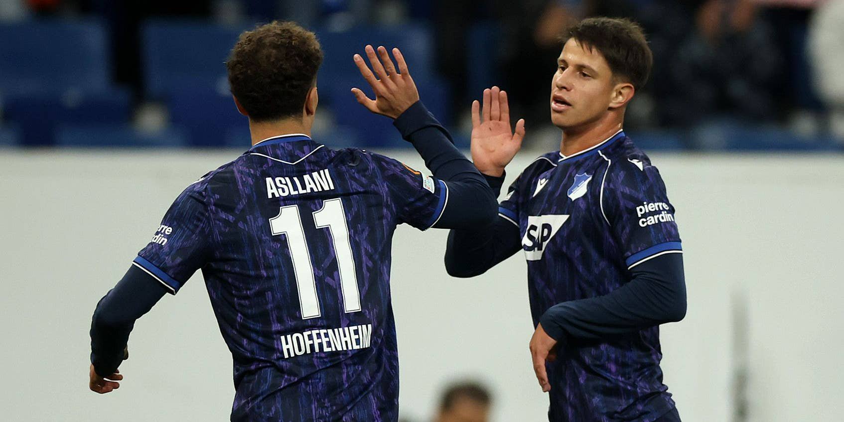 Zwei Hoffenheim-Spieler klatschen sich auf dem Spielfeld jubelnd ab.