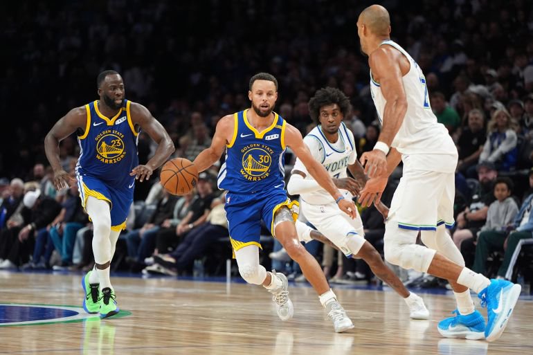 Golden State Warriors guard Stephen Curry (30) dribbles down the court as Minnesota Timberwolves center Rudy Gobert, right, defends during the second half of an NBA basketball game, Wednesday, Oct. 28, 2026, in Minneapolis. (AP Photo/Abbie Parr)