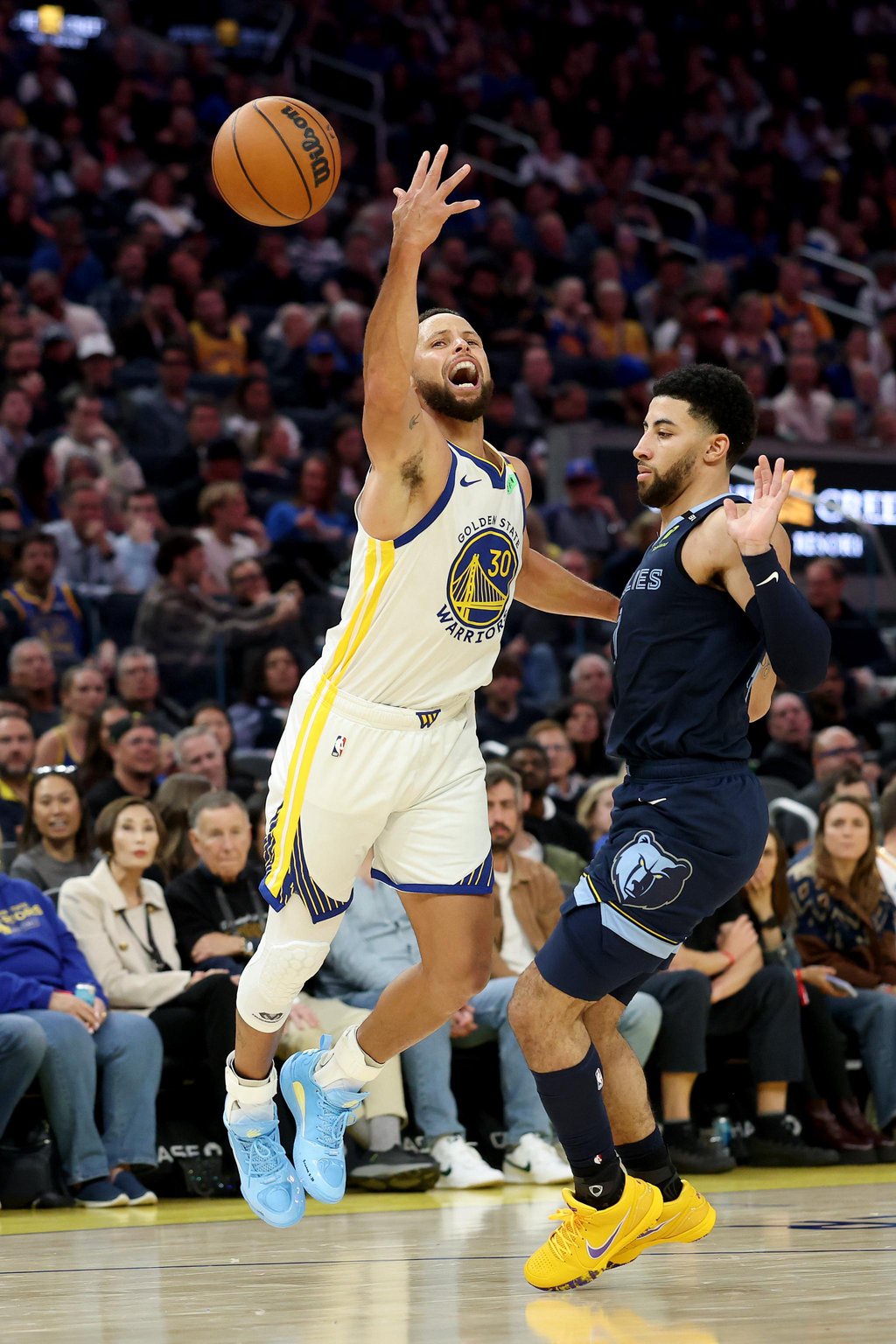 Stephen Curry of the Golden State Warriors is fouled by Scotty Pippen Jr. of the Memphis Grizzlies during an NBA basketball game.