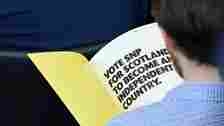 Reuters A man reads the SNP manifesto