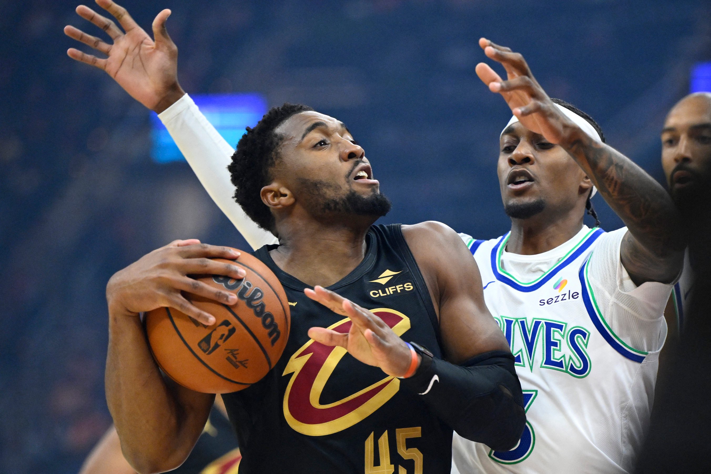Cleveland Cavaliers guard Donovan Mitchell (45) drives to the basket while defended by Minnesota Timberwolves forward Jaden Mcdaniels (3) on Oct. 26, 2026, in Cleveland.