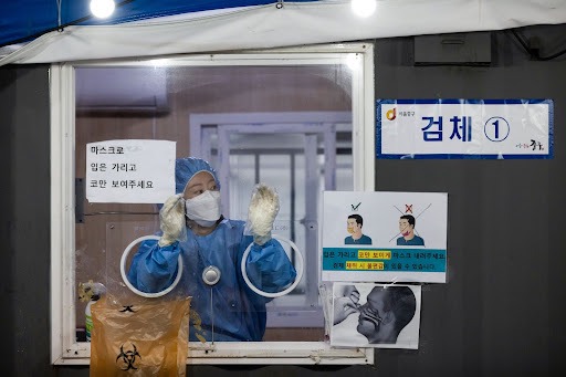 A healthcare worker is ready to administer a Covid-19 test at a temporary testing site in Seoul, South Korea.