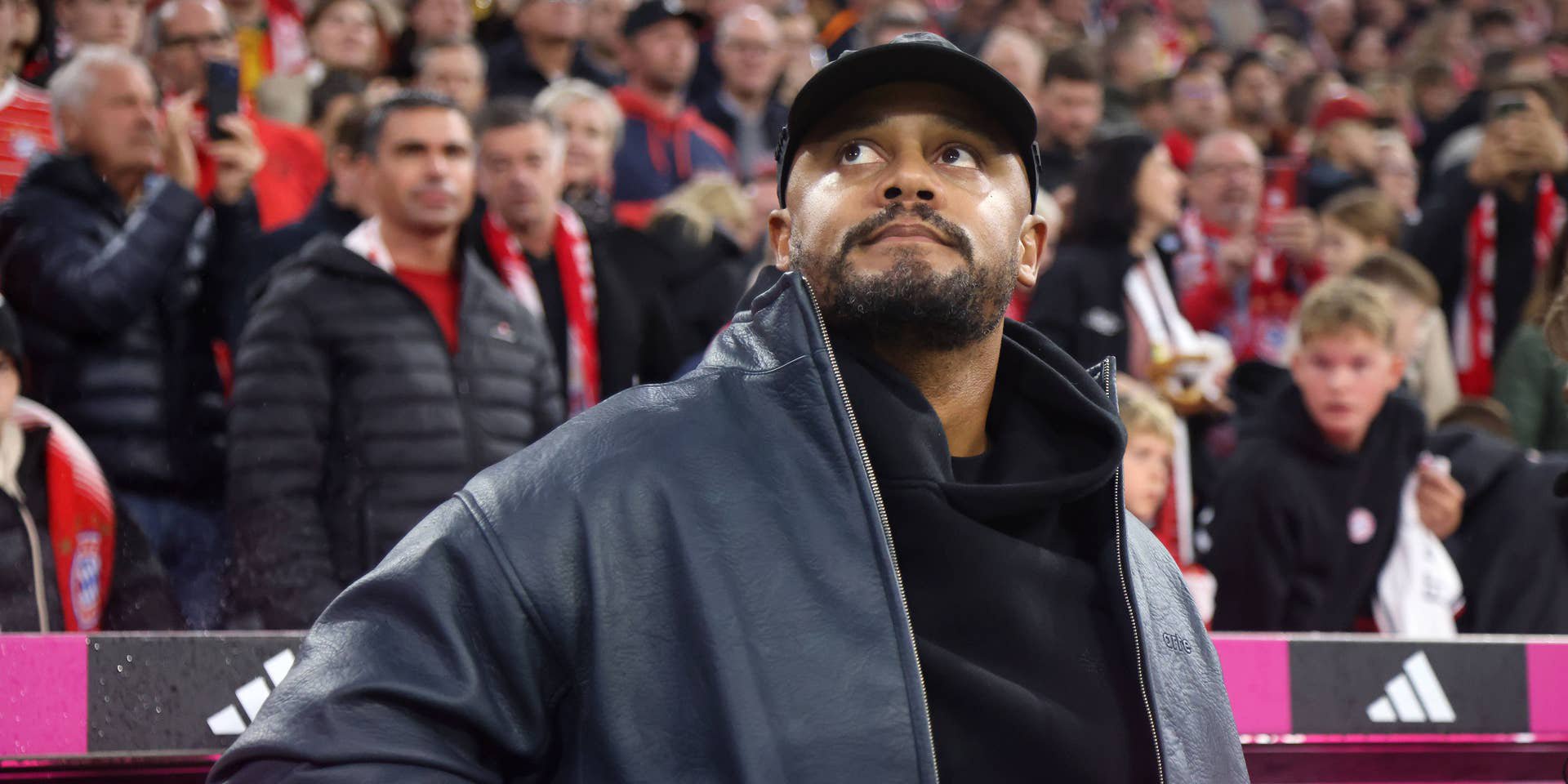 Vincent Kompany, Trainer des FC Bayern München, blickt nach oben im Stadion vor vielen Fans.