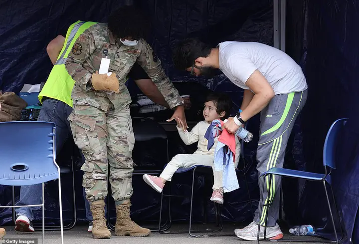A military medic cares for a young child at the Ramstein Air Base on August 26. Some children have arrived there alone