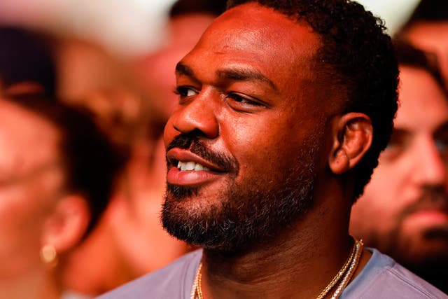 Jon Jones sitting cageside at UFC 327 in April