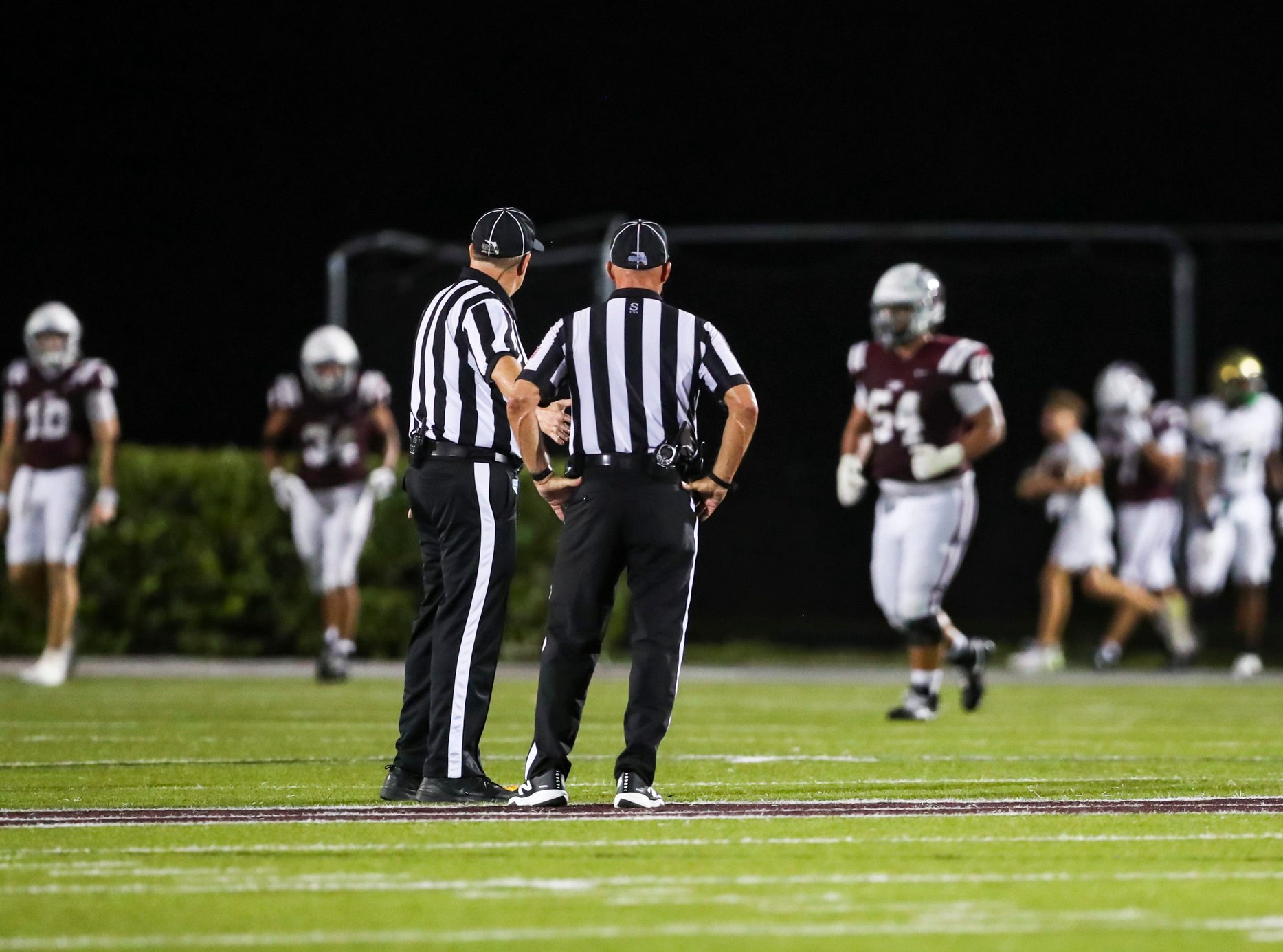 Referees discuss a penalty call during the second quarter of a district game between the First Baptist Academy Lions and the Neumann Celtics at First Baptist Academy in Naples, Fla., on Friday, Oct. 9, 2026.