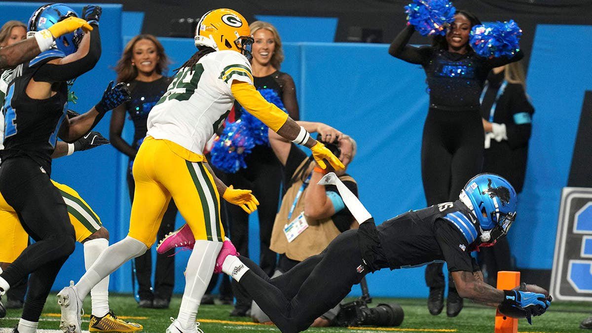 Jameson Williams dives toward the end zone during an NFL game against the Green Bay Packers.