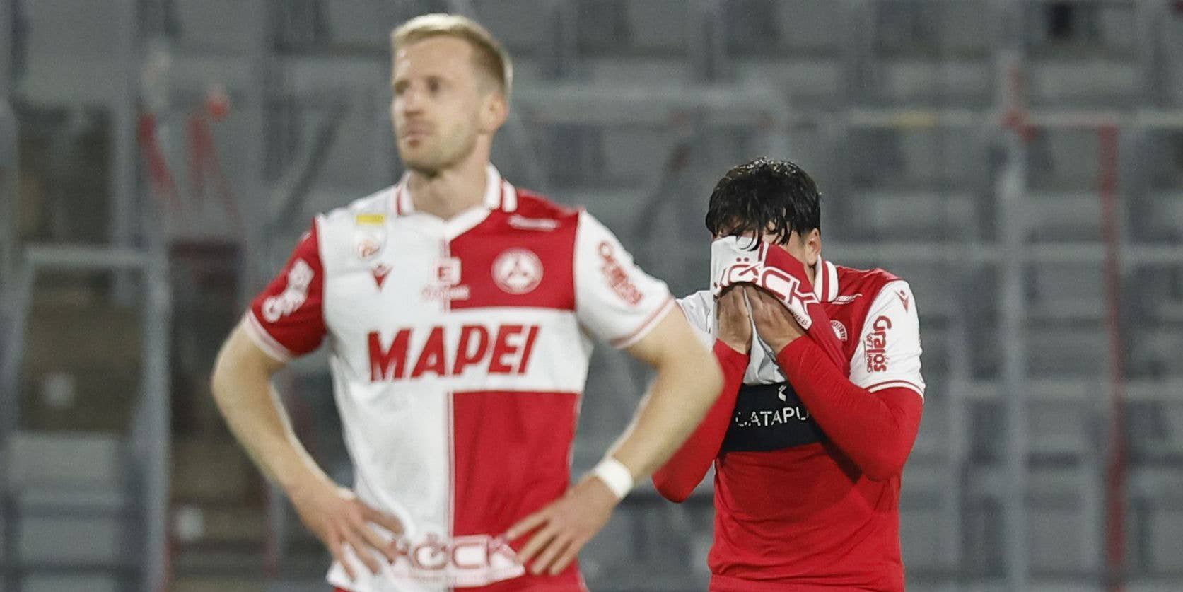 Ein enttäuschter GAK-Spieler schlägt sich das Trikot über das Gesicht, während ein Mitspieler mit gesenktem Kopf daneben steht.