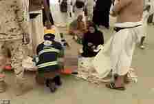 Horrific pictures show bodies in the streets being taken away by health workers at the hajj