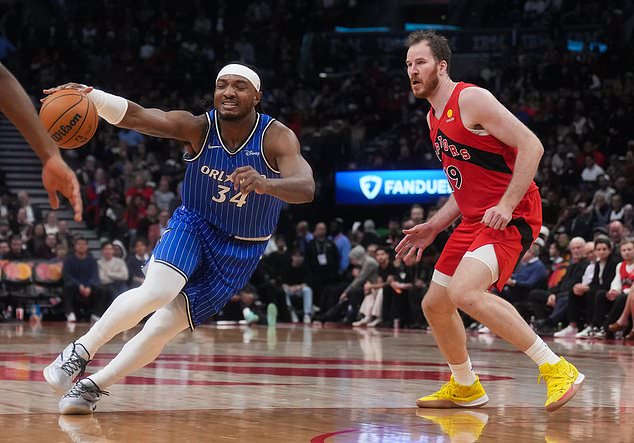 Orlando Magic's Wendell Carter Jr. (34) tries too drive past Toronto Raptors' Jakob Poeltl (19) during second half of an NBA basketball game in Toronto, Wednesday, Oct. 28, 2026. (Nathan Denette/The Canadian Press via AP)