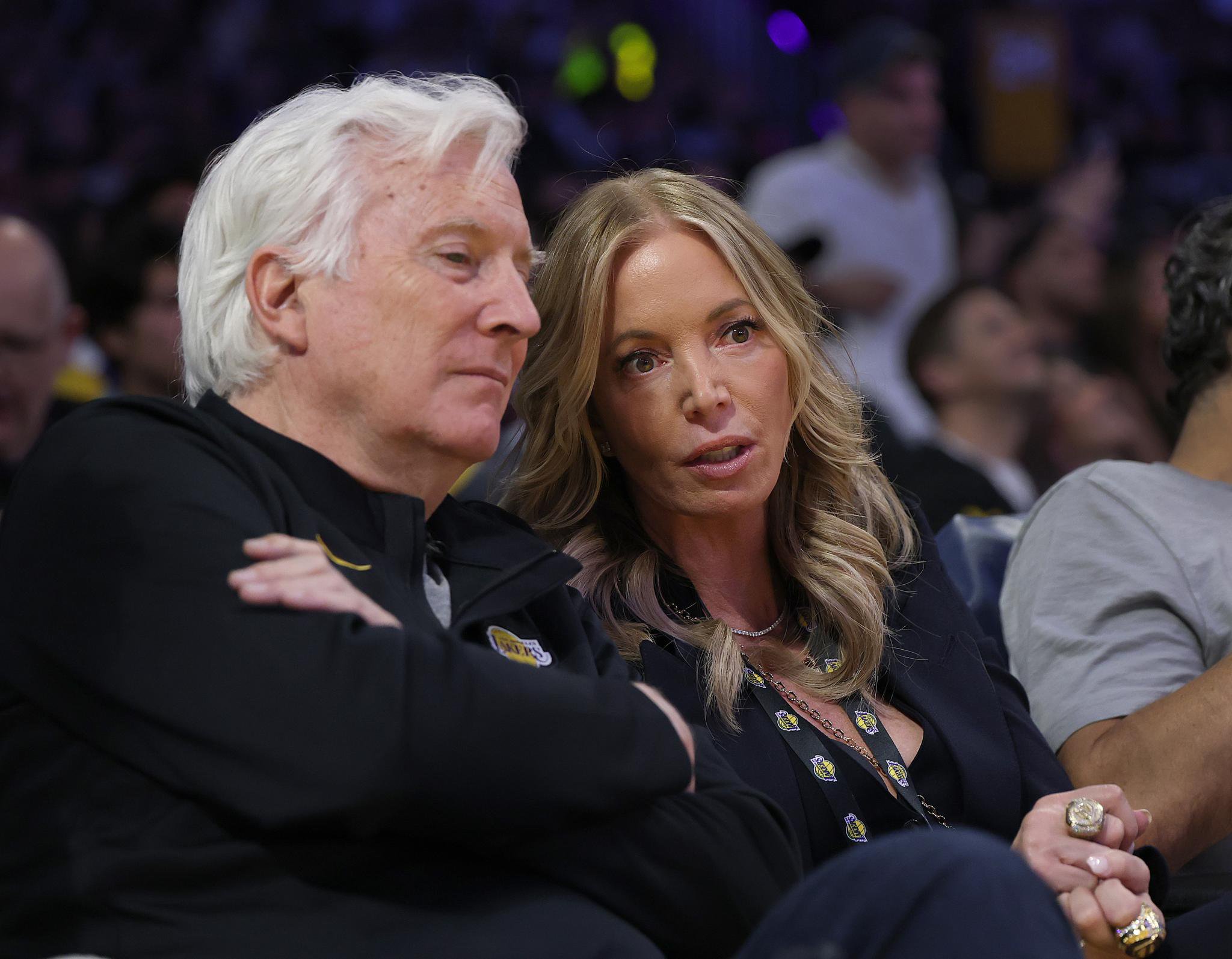 Mark Walter and Jeanie Buss talking courtside at a Lakers game.