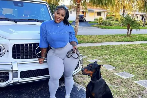 Rahki Giovanni poses for a photo with her car and her dog