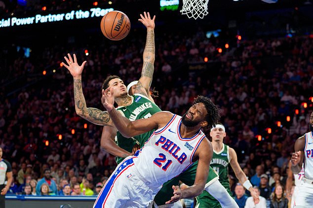 Philadelphia 76ers' Joel Embiid, right, reacts to being fouled by Milwaukee Bucks' Kyle Kuzma, left, as he went up for the shot during the first half of an NBA basketball game, Saturday, Oct. 24, 2026, in Philadelphia. (AP Photo/Chris Szagola)
