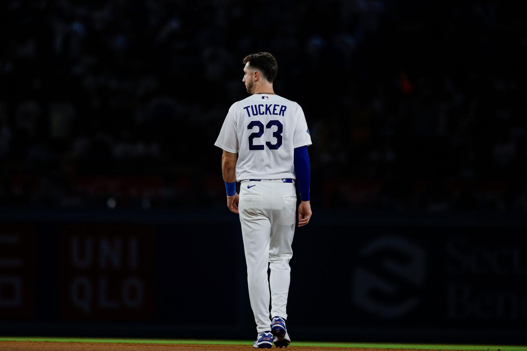 Dodgers outfielder Kyle Tucker walks on the field, seen from behind, wearing a white jersey with “TUCKER 23” on the back.