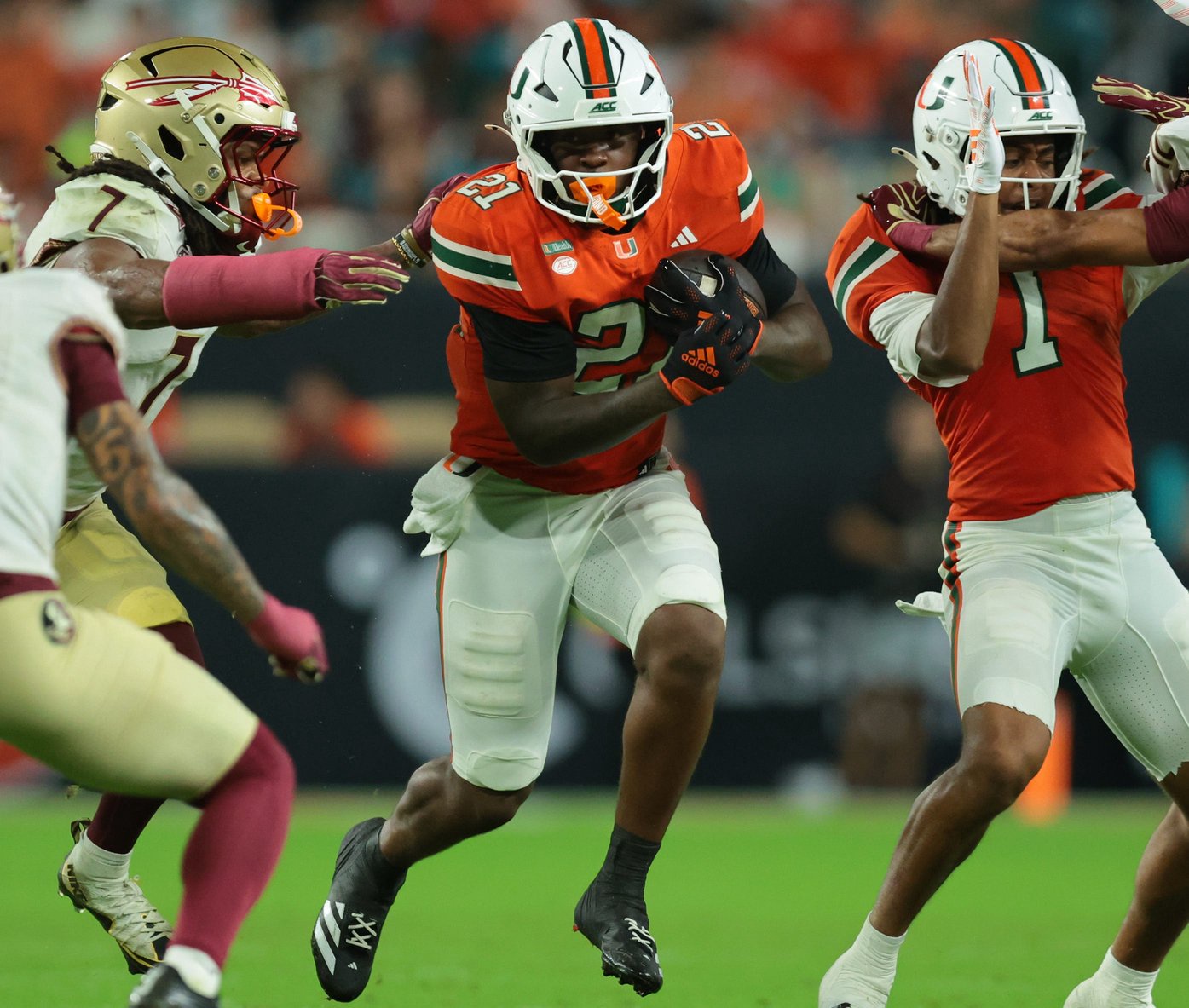 Miami running back Javian Mallory (21) carries the ball as Florida State defensive back Ashlynd Barker (7) tries to make a tackle during the third quarter at Hard Rock Stadium. 