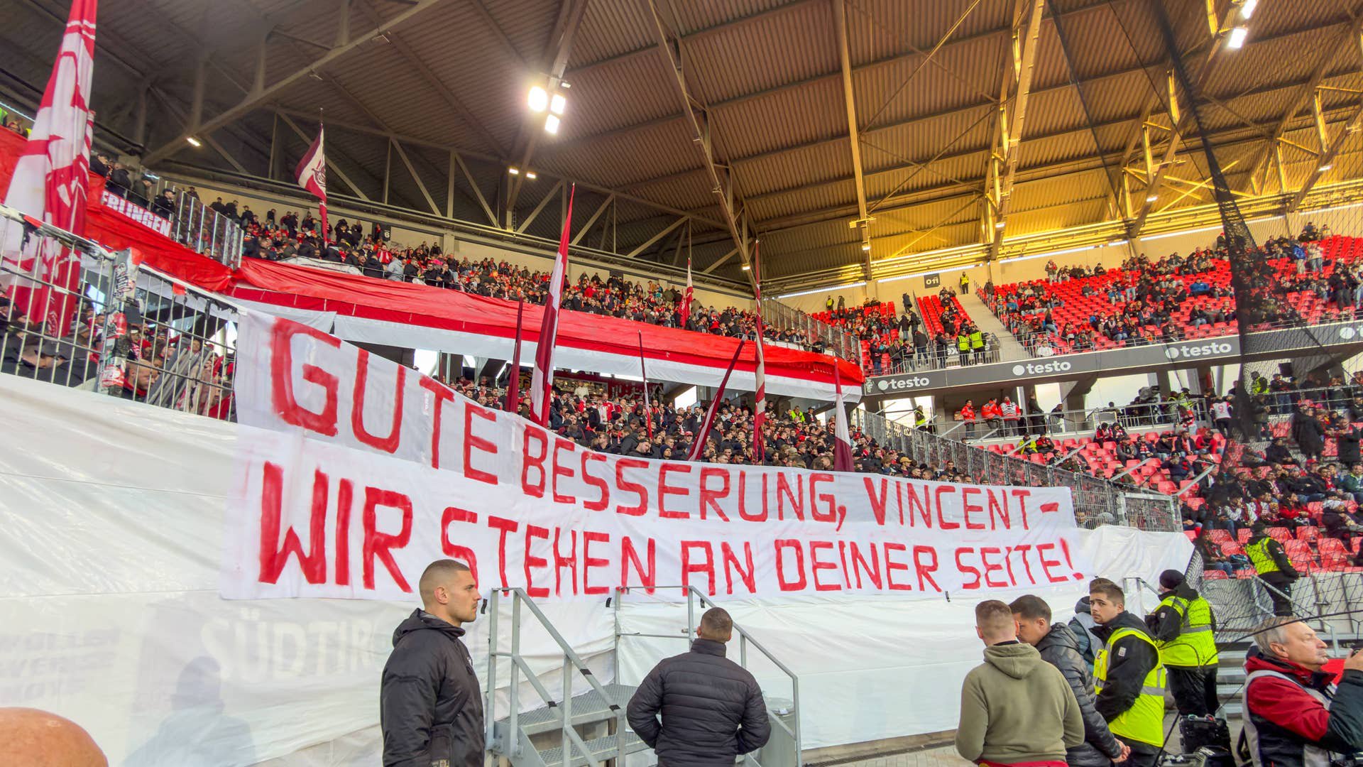 Bayern-Fans halten im Stadion ein Banner mit Genesungswünschen für Vincent Kompany hoch.