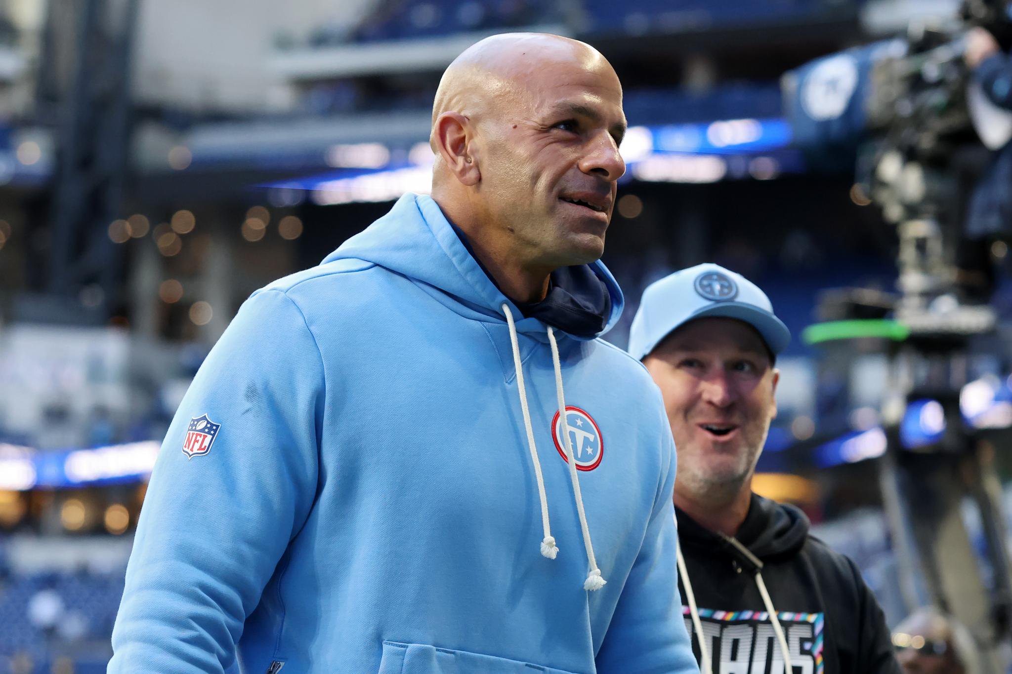 Tennessee Titans head coach Robert Saleh smiling as he walks off the field after a game.