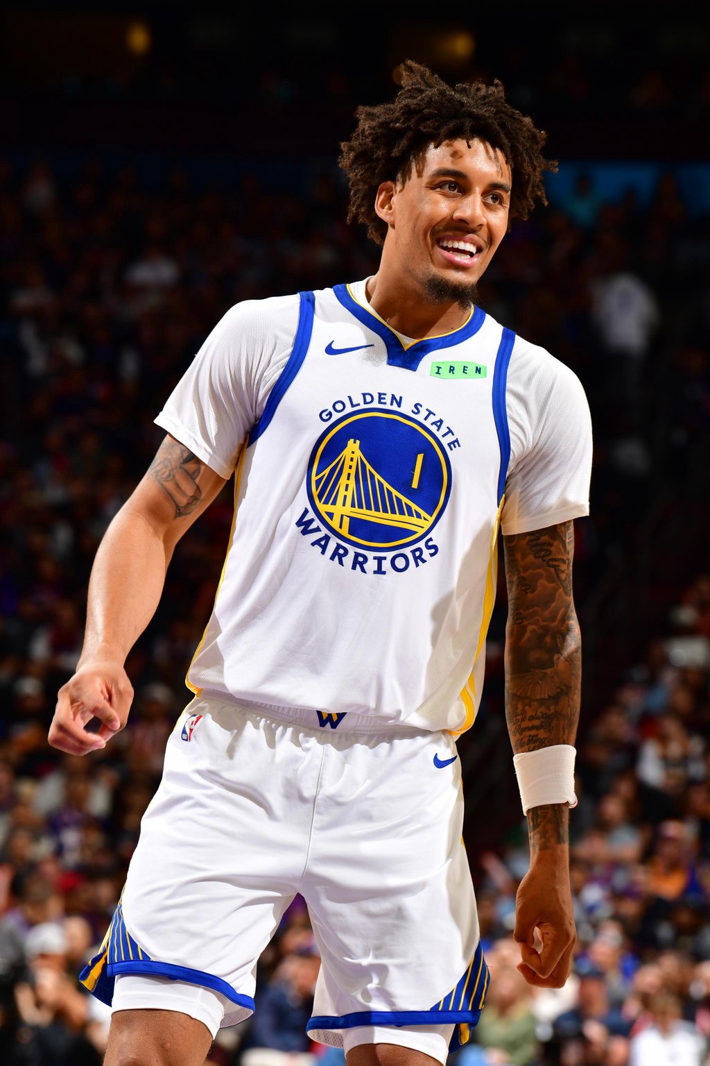 Golden State Warriors player smiling on the court.