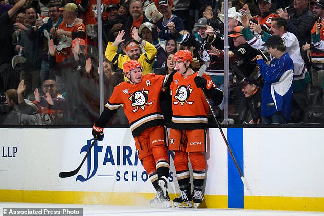 Anaheim Ducks right wing Beckett Sennecke, right, celebrates his goal with defenseman Jackson LaCombe during the first period of an NHL hockey game against the Calgary Flames, Tuesday, Oct. 13, 2026, in Anaheim, Calif. (AP Photo/Kyusung Gong)