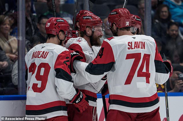 Carolina Hurricanes' Nicolas Deslauriers, center, celebrates his goal against the Vancouver Canucks with his teammates during the second period of an NHL hockey game in Vancouver, British Columbia, Tuesday, Oct. 20, 2026. (Ethan Cairns/The Canadian Press via AP)