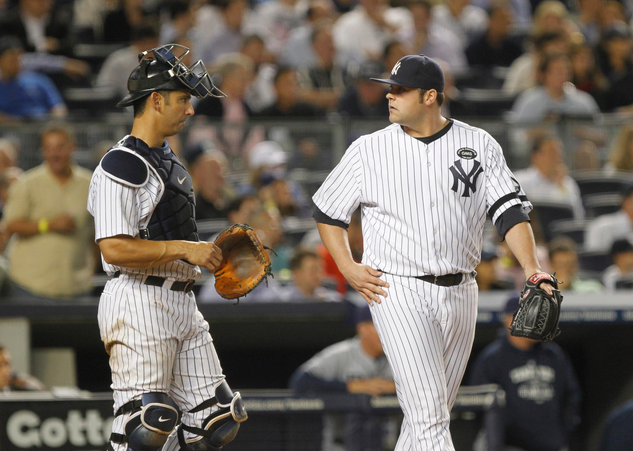 New York Yankees pitcher Joba Chamberlain and catcher Jorge Posada react on the field.
