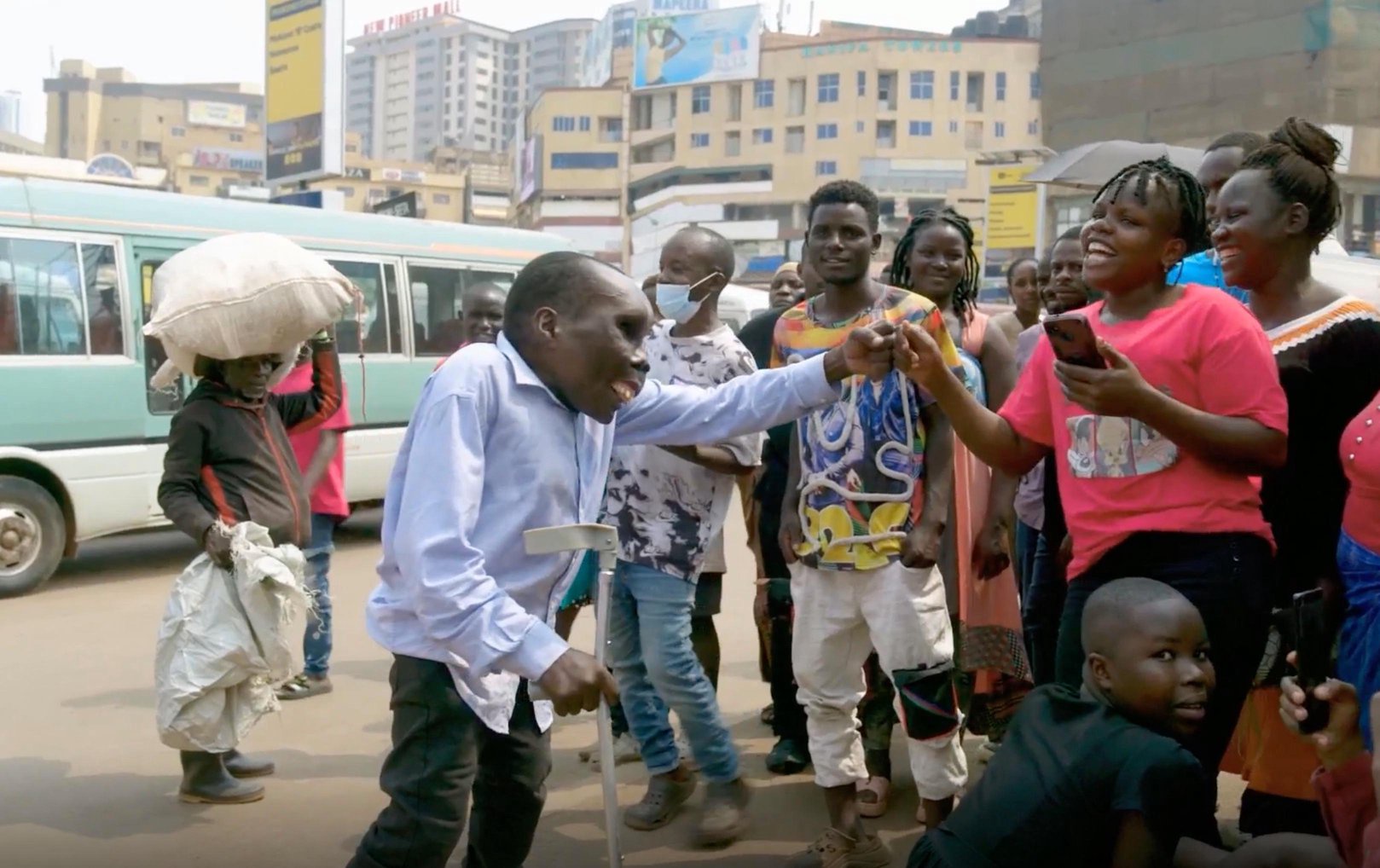 Godfrey Baguma from Uganda surrounded by a crowd of people.
