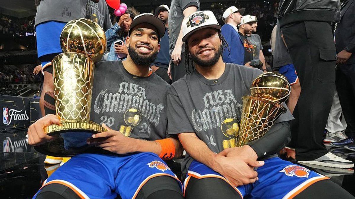 Karl-Anthony Towns and Jalen Brunson celebrate winning the NBA Championship holding trophies