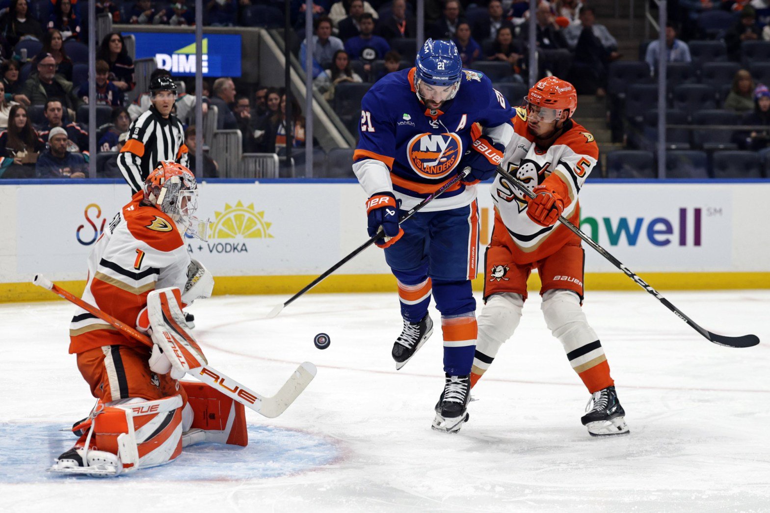 Ducks goaltender Lukas Dostal, left, and defenseman Tyson Hinds, right, defend against New York Islanders center Kyle Palmieri during the second period on Tuesday night in Elmont, N.Y. The Ducks lost their fourth straight game, 3-2. (AP Photo/Adam Hunger)
