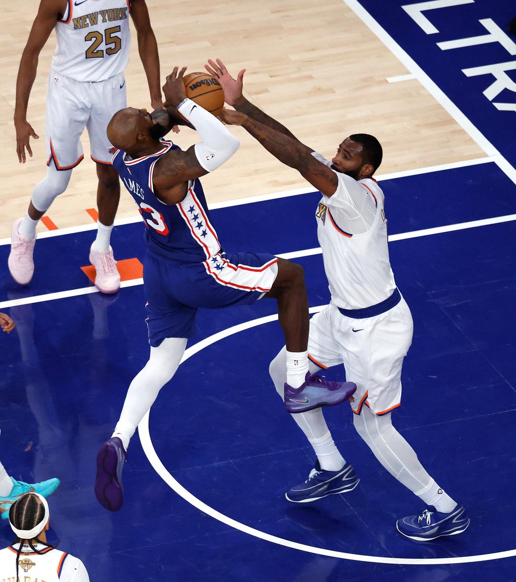 Philadelphia 76ers forward LeBron James drives to the basket as New York Knicks center Andre Drummond defends.