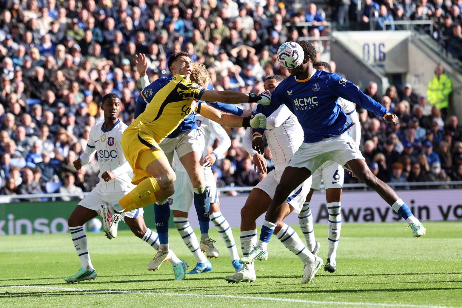 Momento exato do choque entre o goleiro Dibu Martínez, do Chelsea, e o zagueiro Jarrad Branthwaite, do Everton, que levou o argentino a sair de ambulância do Hill Dickinson Stadium em partida da Premier League 2026/27 - 
