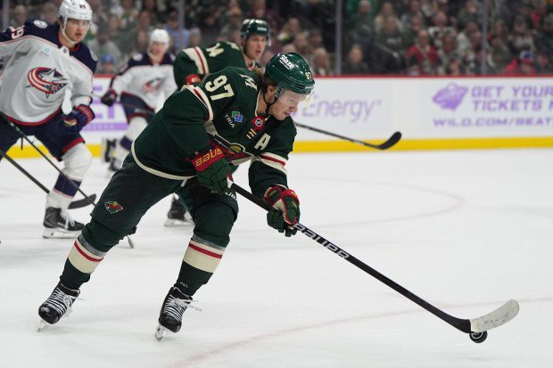 A hockey player gets control of the puck.