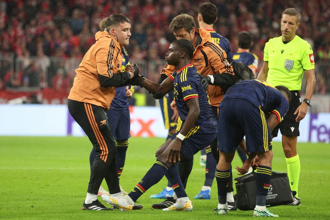 Bukayo Saka being helped by Arsenal physios.