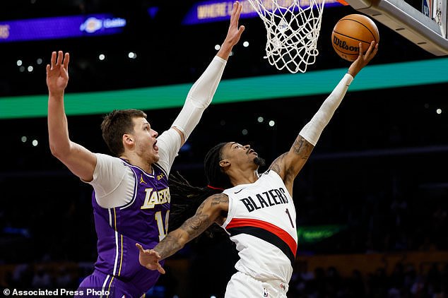 Portland Trail Blazers guard Ja Morant (1) drives to the basket as Los Angeles Lakers center Walker Kessler, left, defends during the first half of an NBA basketball game Tuesday, Oct. 27, 2026, in Los Angeles. (AP Photo/Caroline Brehman)