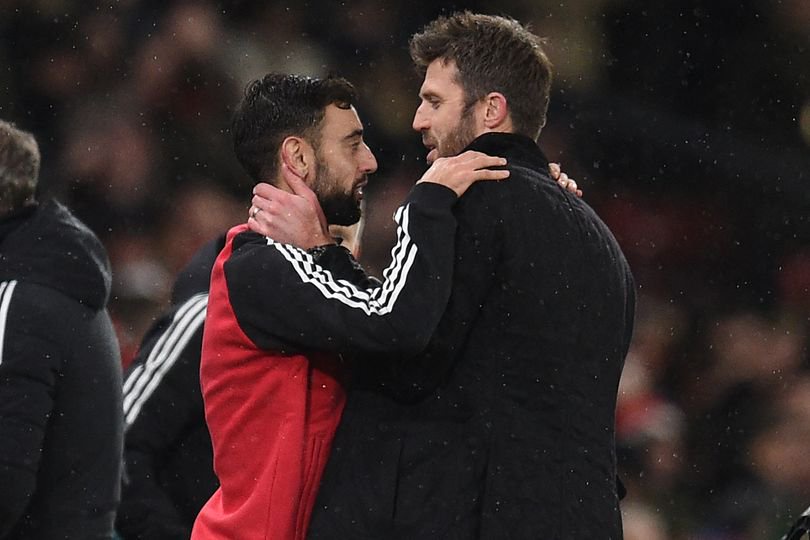 Manchester United's manager Michael Carrick (R) speaks with Manchester United's Portuguese midfielder Bruno Fernandes (L)